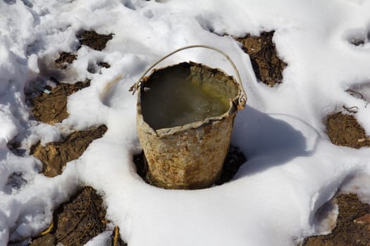 an old rusty bucket in the snow