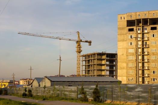 Not completed houses and tower crane in Kazakhstan. Shymkent 