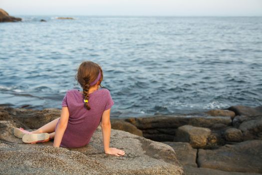Little girl siting by the sea in Maine