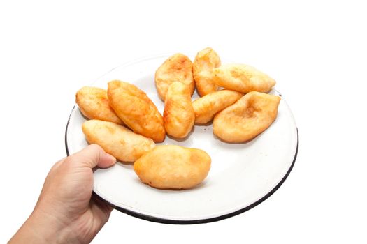 hand holding a tasty pies on a plate isolated on white background. 