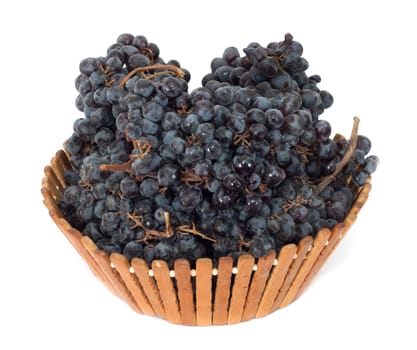 black grapes in a basket on a white background