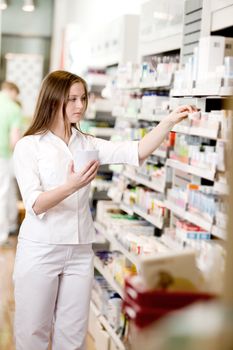 Attractive young pharmacist filling prescription
