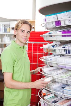 Portrait of smiling man holding medicine box at drugstore