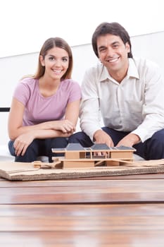 Two happy architects with house model  .