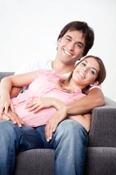 Portrait of young couple sitting close on couch.
