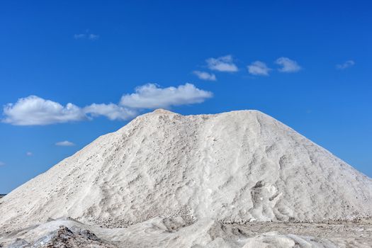 Big pile of freshly mined salt, set against a blue sky