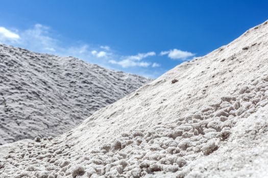 Big pile of freshly mined salt, set against a blue sky