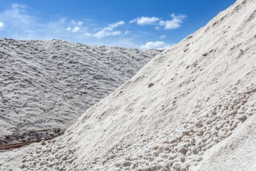 Big pile of freshly mined salt, set against a blue sky