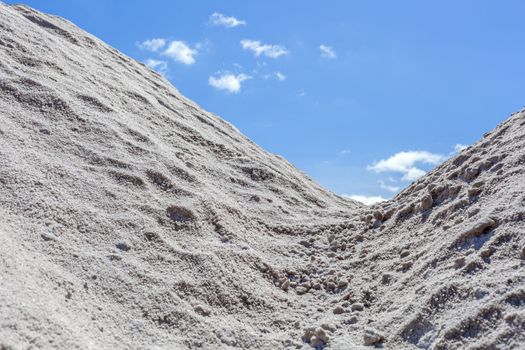 Big pile of freshly mined salt, set against a blue sky