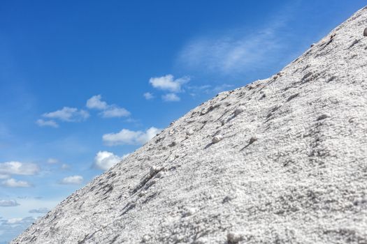 Big pile of freshly mined salt, set against a blue sky