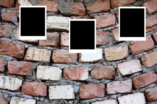 set of three old blank polaroids frames lying on a brick surface 