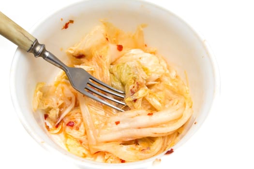 Korean cabbage with chili and a fork on a white background