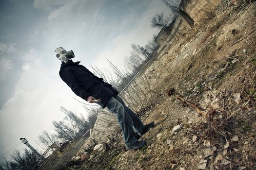 Human in the gas mask in postapoplectic landscape with toxic air. Vibrant color and moody darkness added