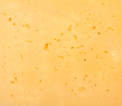 Background of fresh yellow Swiss cheese with holes 
