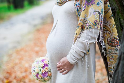 pregnant woman with flowers next to the road