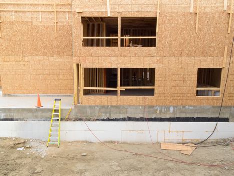 Exterior view of new home construction with still empty window openings being a deserted building site like after construction company went bankrupt