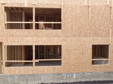 Exterior view of new home construction with still empty window openings being a deserted building site like after construction company went bankrupt