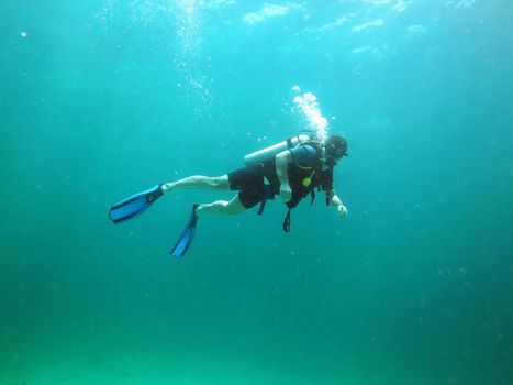 Young Man Scuba Diver between Water Surface