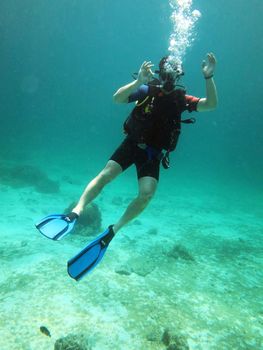 Young Man Scuba Diver between Water Surface 