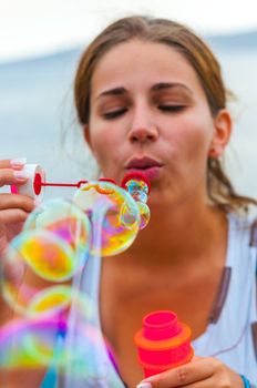 Young woman blowing bubbles outdoors