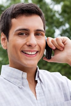 Portrait of happy young man answering a phone call