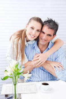 Happy woman embracing her husband at breakfast .