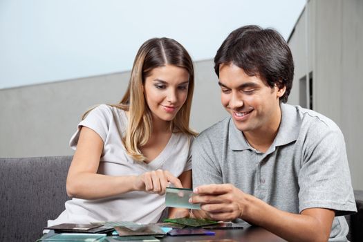 Young couple choosing between various glass tile swatches