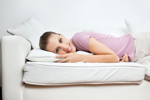 Portrait of beautiful young woman relaxing on sofa at home