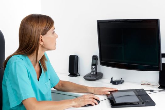 Female dentist using computer at office desk