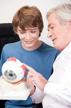 Optometrist showing medical eye model.