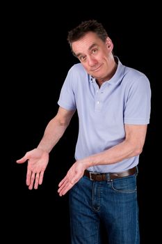 Smiling Middle Age Man Shrugging Hands Forward Pointing at Something Black Background