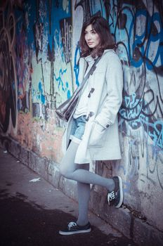 Beautiful stylish woman listening to music in the street 