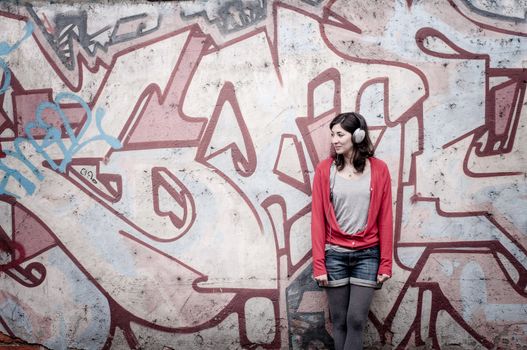 Beautiful stylish woman listening to music in the street 