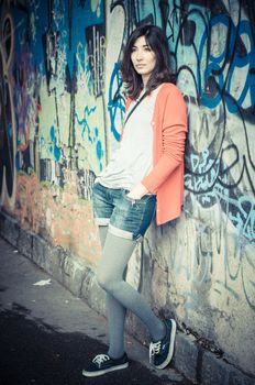 Beautiful stylish woman listening to music in the street 