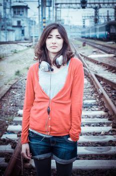 Beautiful stylish woman listening to music in railway