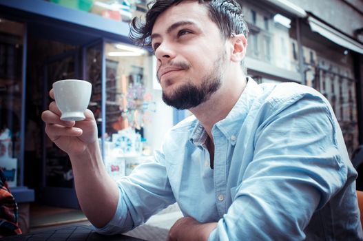 stylish man drinking a coffee at the bar in the city