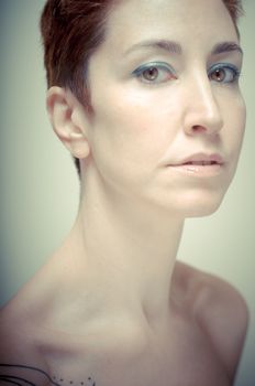 beautiful girl with short red hair on gray background