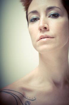 beautiful girl with short red hair on gray background