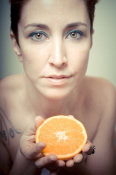 beautiful girl with short red hair and fruit on gray background