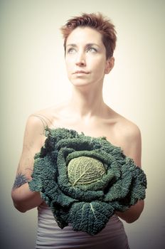 beautiful girl with short red hair and vegetable on gray background
