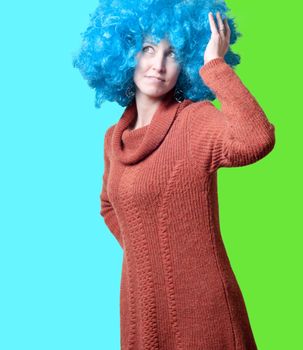 beautiful girl with curly blue wig and turtleneck on colorful background