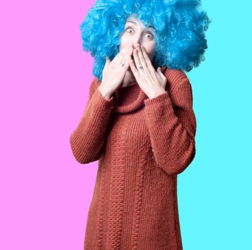 beautiful girl with curly blue wig and turtleneck on colorful background
