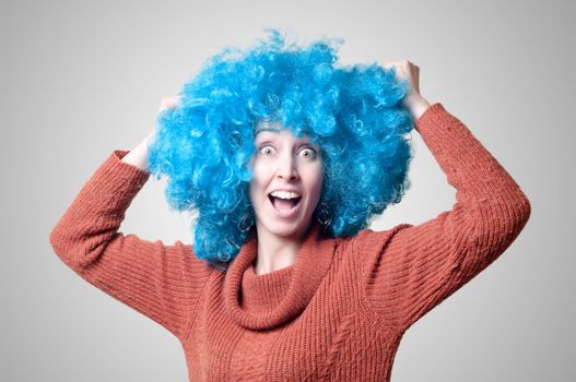 beautiful girl with curly blue wig and turtleneck on colorful background