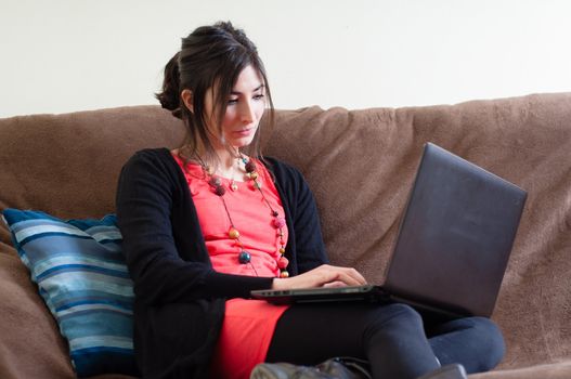 woman at home using notebook on couch