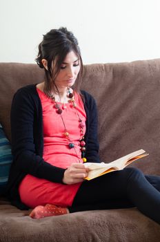 woman at home reading book on couch