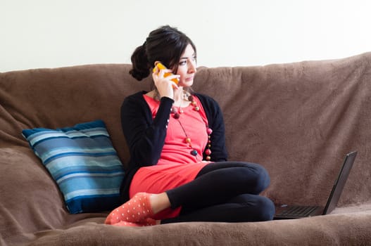 woman at home using notebook on couch