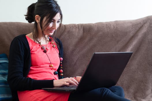 woman at home using notebook on couch