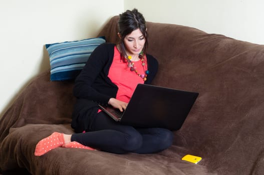 woman at home using notebook on couch