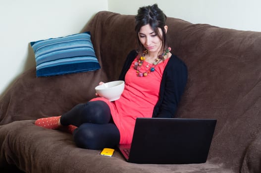 woman at home using notebook on couch