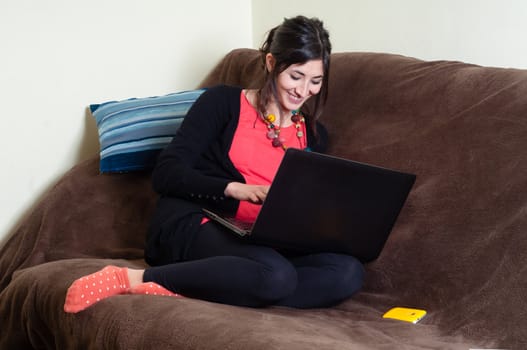 woman at home using notebook on couch